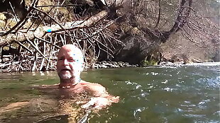 naked uncut bear chilling in the river